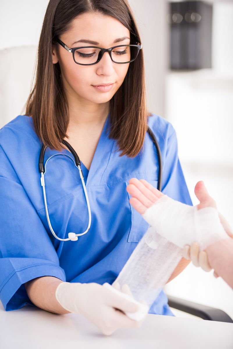 doctor wrapping a patients hand in gauze